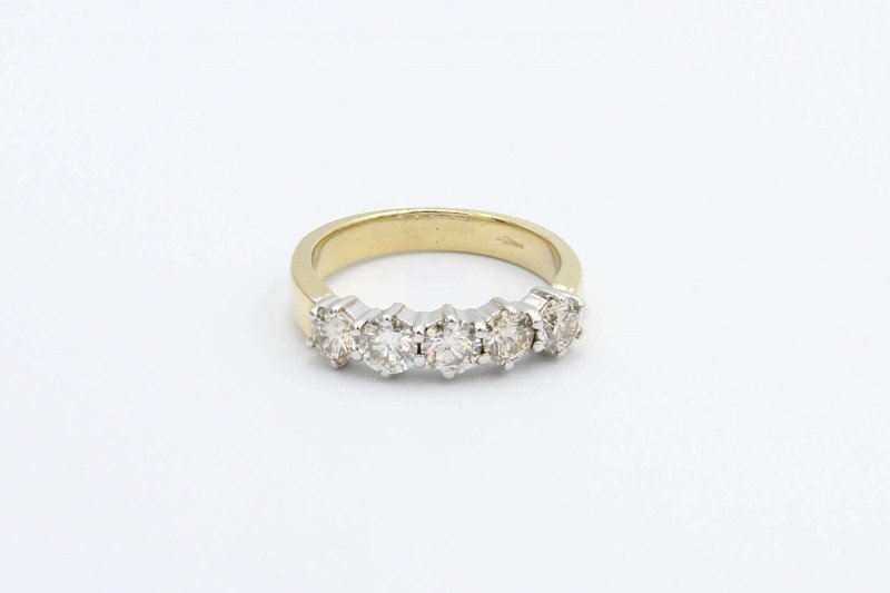 a gold and diamond anniversary ring on a white background