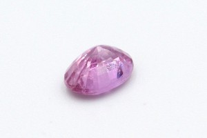 a loose pink sapphire on a white background