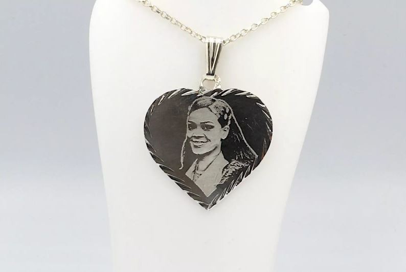 a silver pendant with rihanna laser engraved on its surface