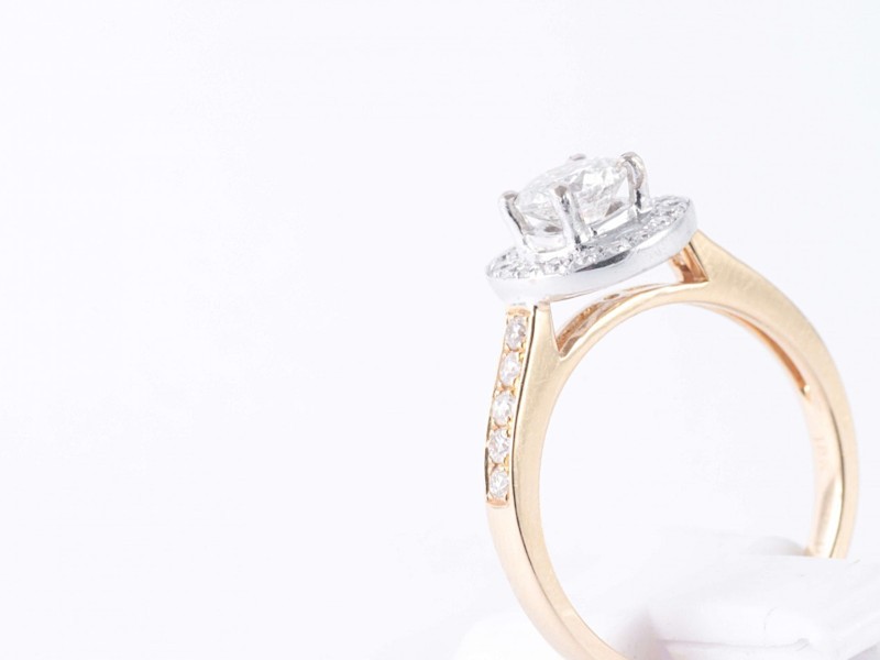 a gold and diamond engagement ring on a white background