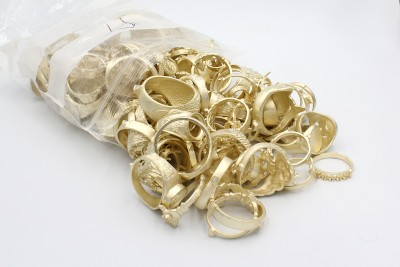 a bag of unpolished golden jewellery on a white background