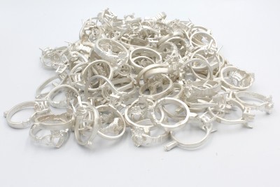 a pile of unpolished white gold rings on a white background