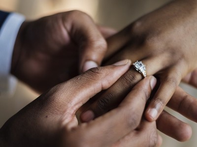 a man putting an engagement ring on his fiancés finger