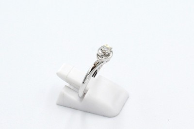 a white gold solitaire engagement ring on a white background