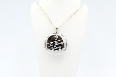a silver round cremation locket and chain engraved with the words 
