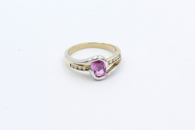 a pink oval sapphire twist ring made from gold adorned with diamond
