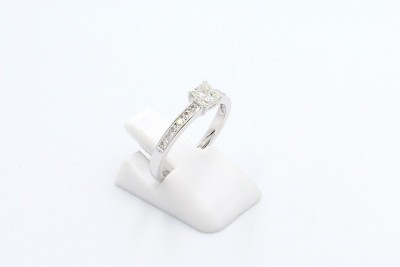 a diamond solitaire ring made from white gold on a white background