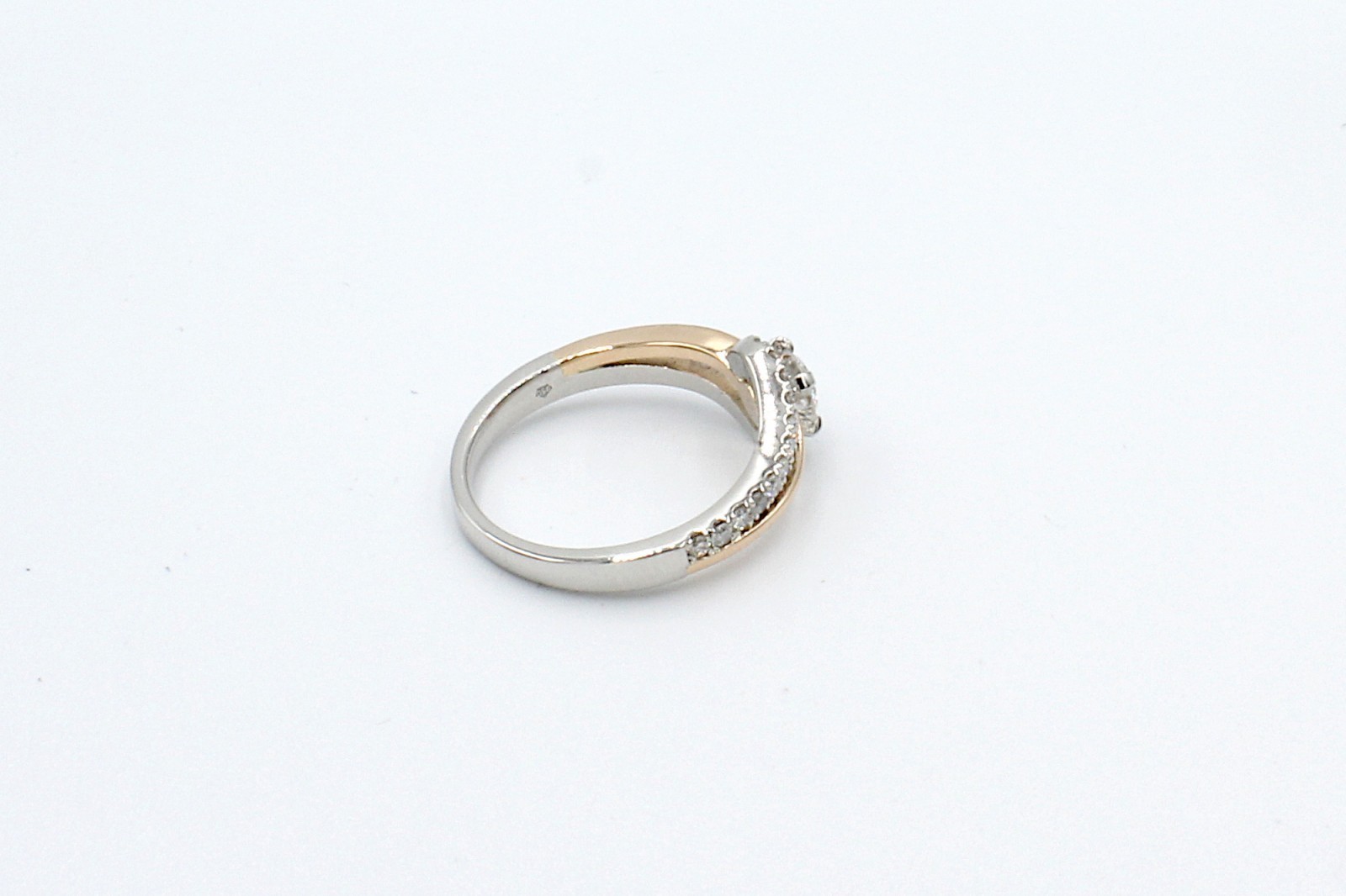 rear view of a repaired engagement ring on a white background