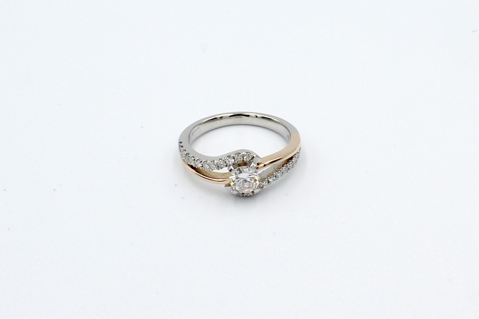 top view of a repaired engagement ring on a white background
