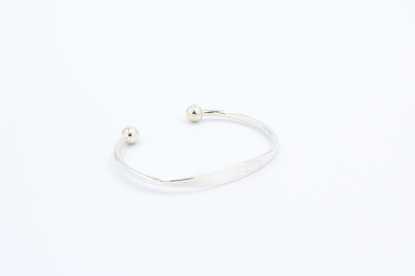 a silver torq baby bangle on a white background