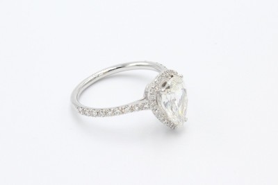 a whitegold pear shaped diamond engagement ring on a white background