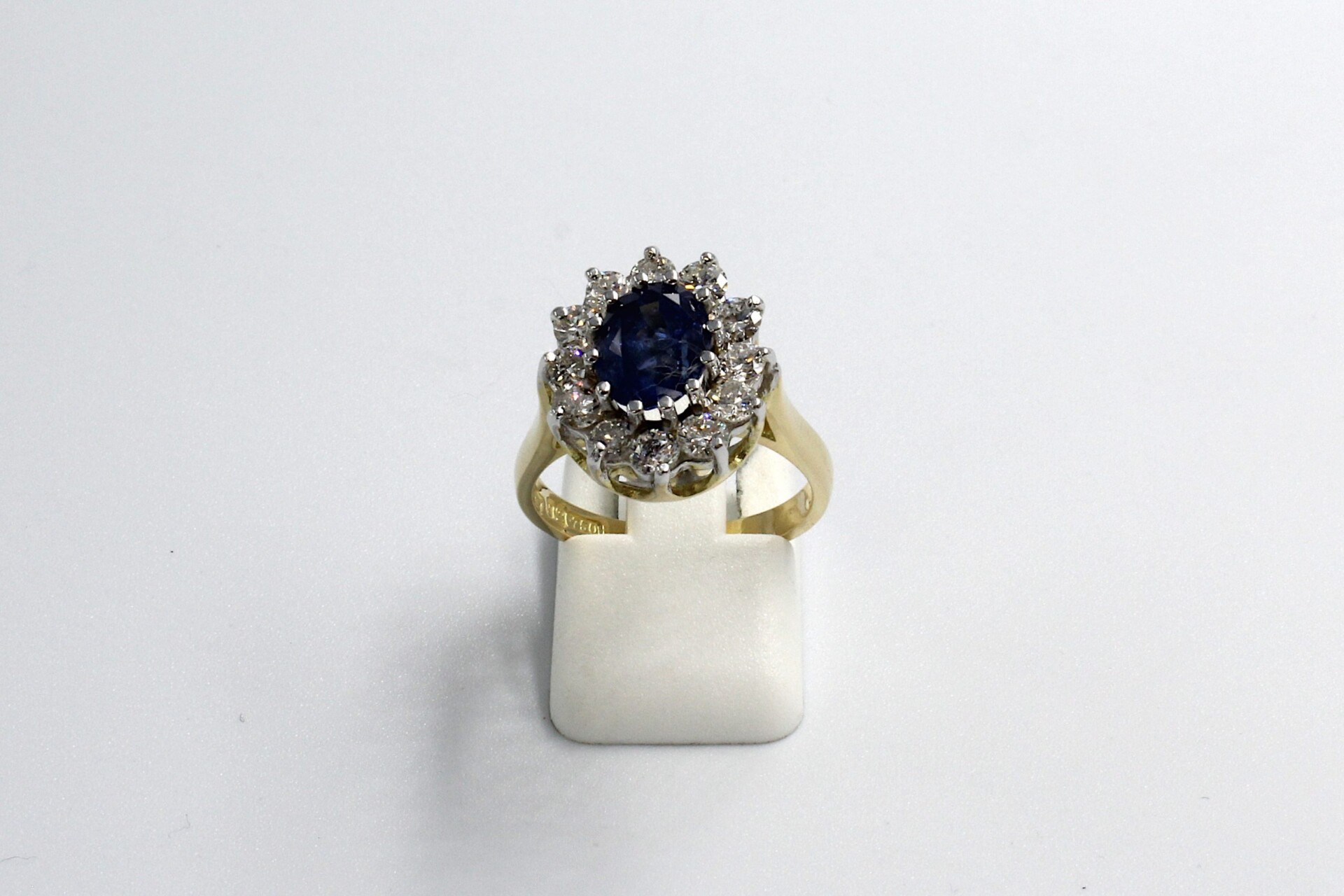 front view of a gold sapphire and diamond cluster engagement ring