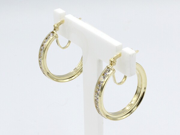 side view of gold cz hoop earrings on white stand