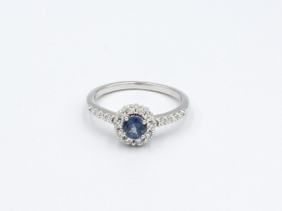 a white gold diamond encrusted engagement ring set with a large blue sapphire
