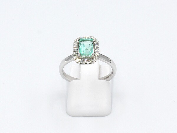 front view of an emerald and diamond halo engagement ring made from platinum.