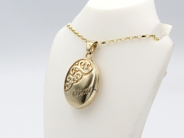a gold engraved oval locket on a gold chain