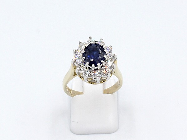 front view of a sapphire and diamond cluster ring made from gold