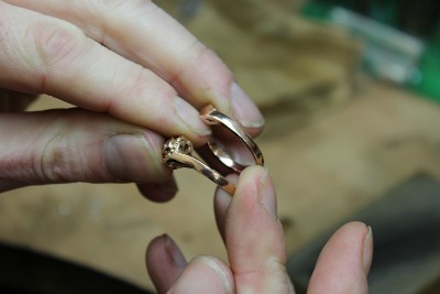 a jeweller holding a new wedding ring suite in his hands
