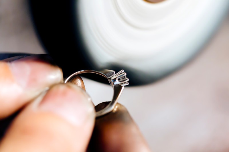 a jeweller polishing an engagement ring on a polishing wheel