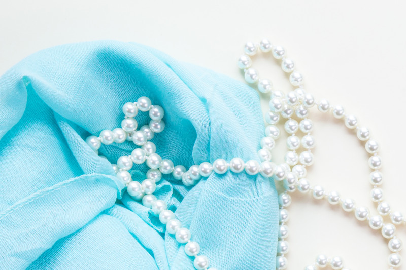 blue fabric cloth with a pearl necklace