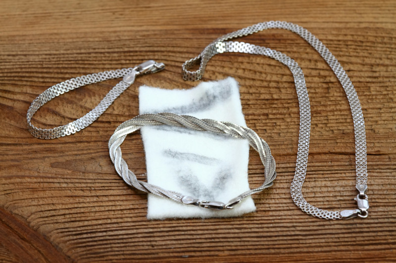 silver jewellery laying ontop of a polishing cloth with dirt marks