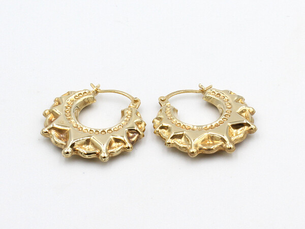 loose gold creole earrings on a white background