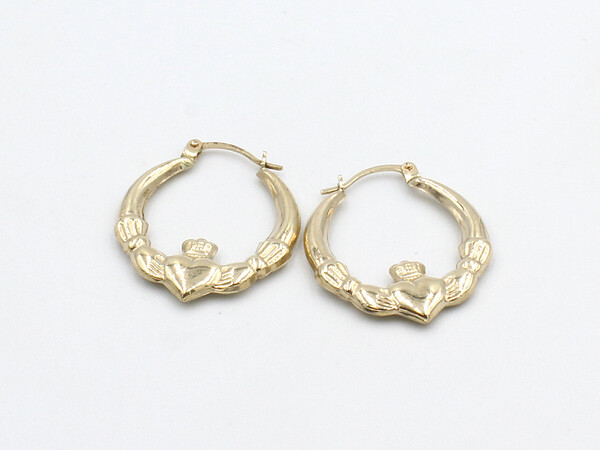 a loose set of claddagh earrings on a white background