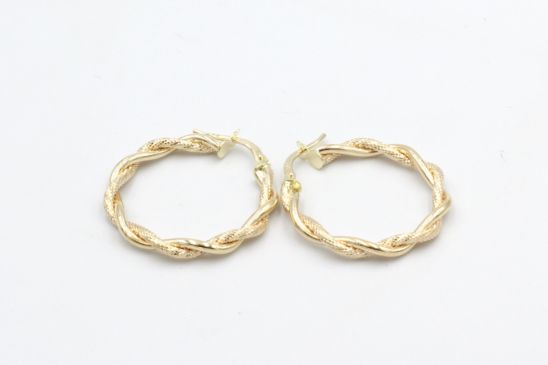 gold twisted hoop earrings on a white background