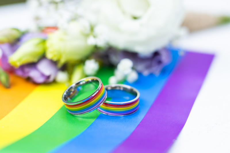 wedding rings on top of a gay pride flag