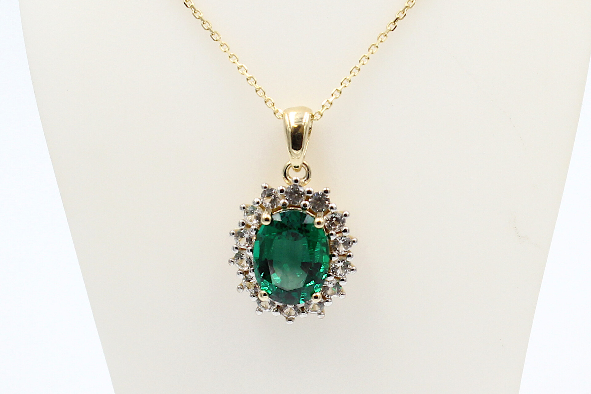 front view of a faux emerald halo pendant on a chain