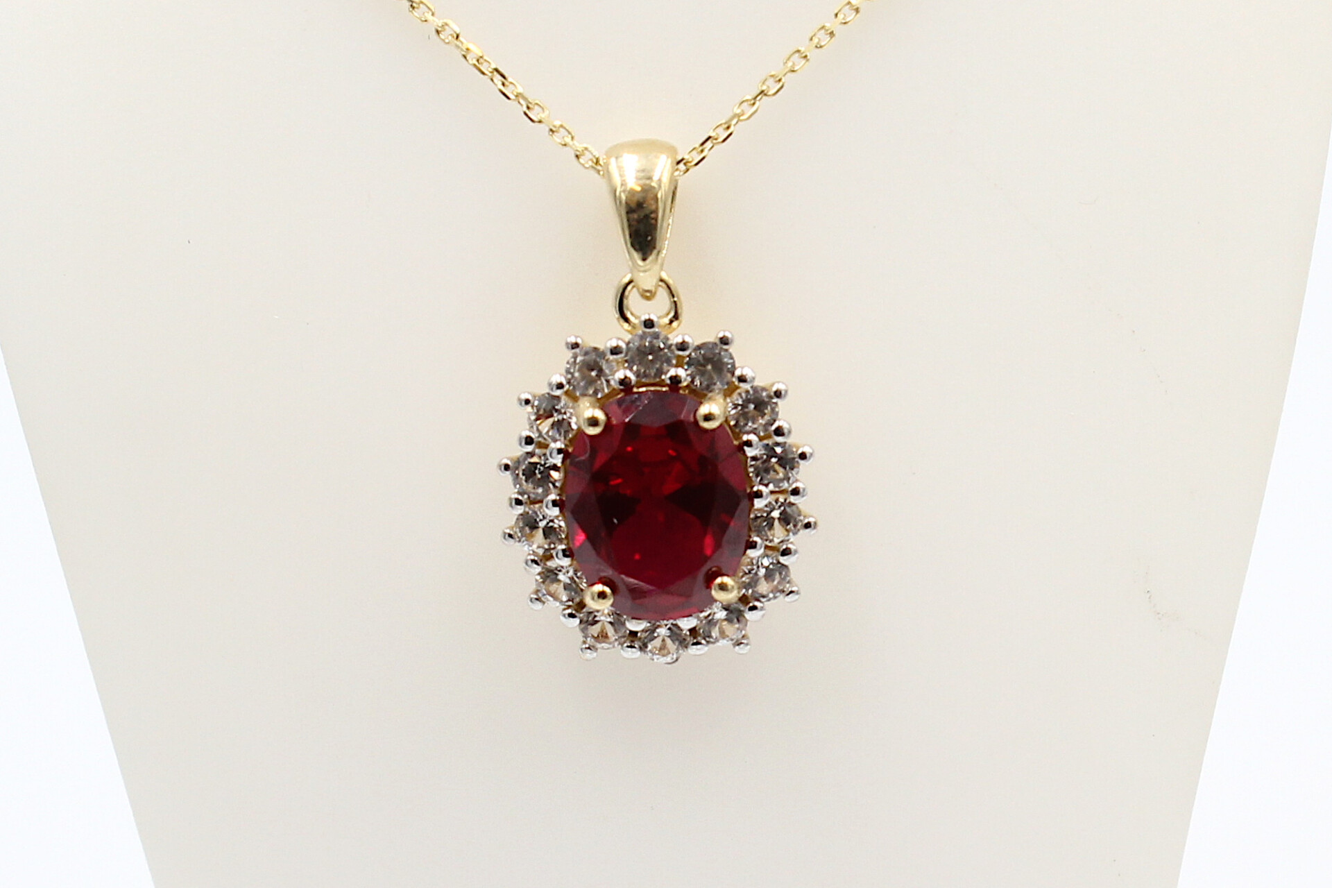 front view of a faux ruby halo pendant on a chain