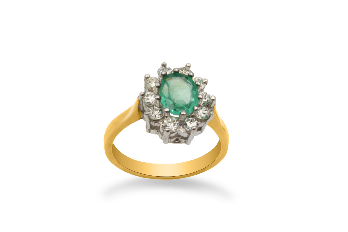 an emerald and diamond cluster engagement ring in yellow gold