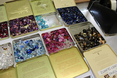 a collection of loose gemstones in containers